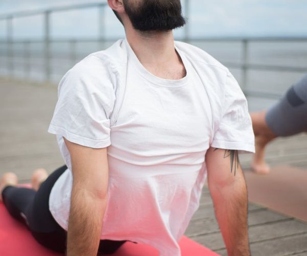Man demonstrates a foundational strength pose on a mat.